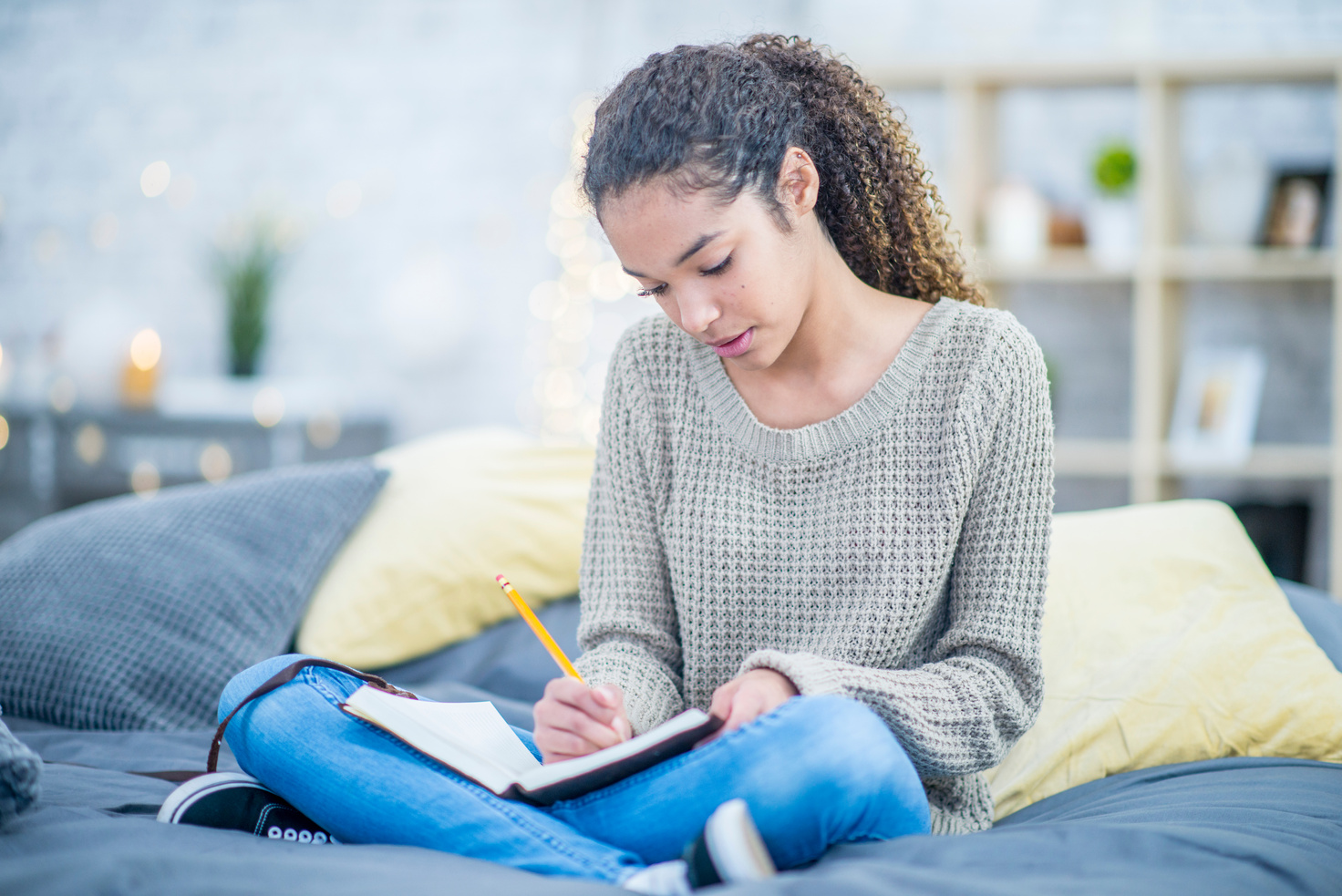 Teen girl journaling on her bed